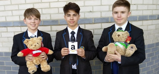 Three male students are pictured holding prizes they have won on Careers Day 2022.