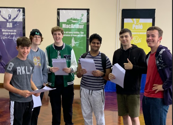 A group of six male students are pictured smiling for the camera after having opened their results on GCSE Results Day 2022.