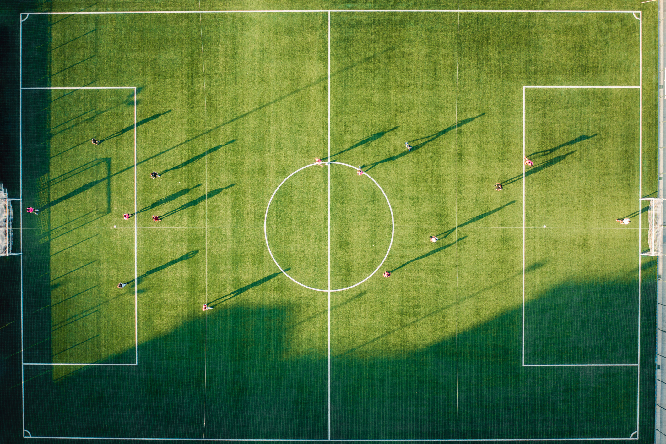 Aerial view of a large Football pitch with players seen dotted around it.