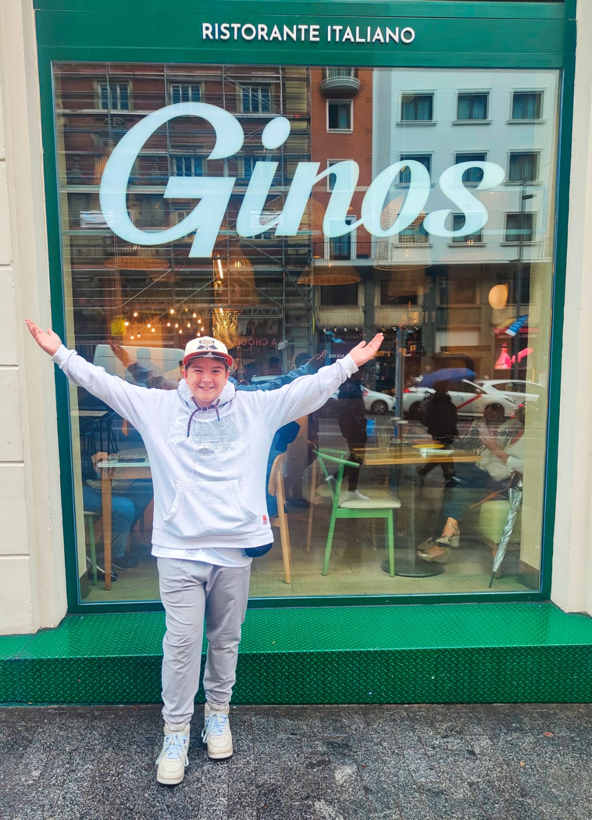 A student posing for a photo in front of a restaurant